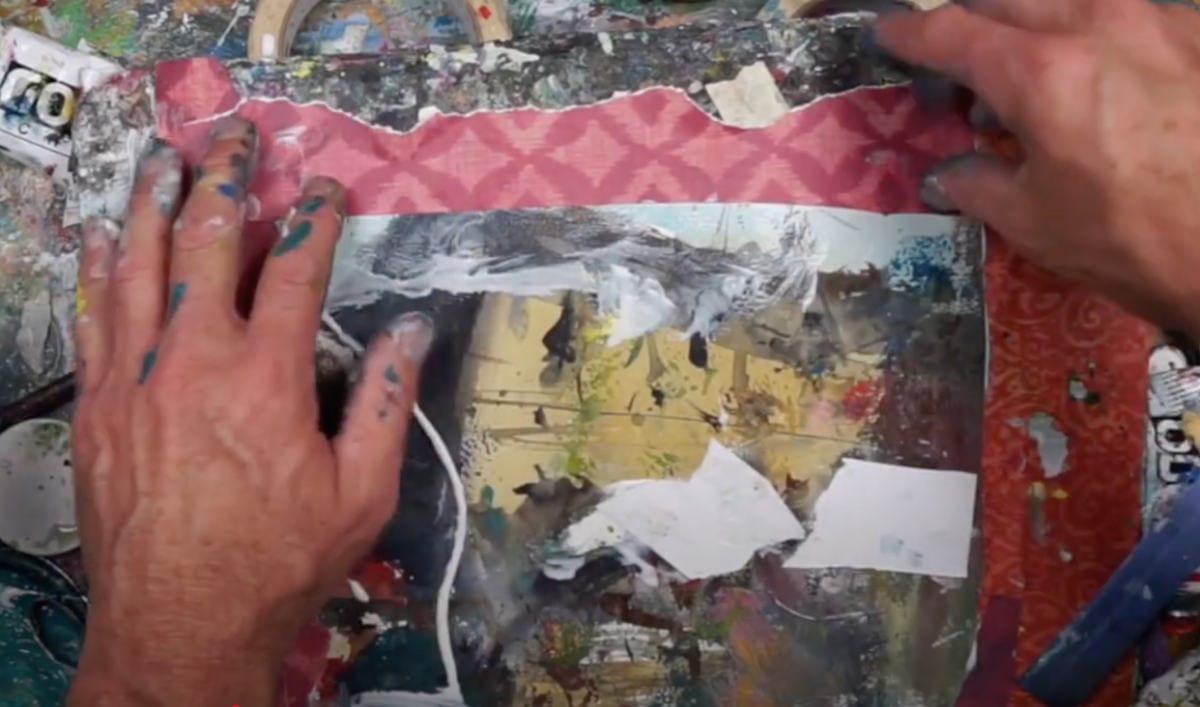 Collage paper border with painted patterns framing a cityscape sketch.