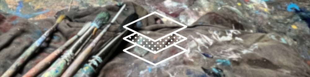 Art table with paintbrushes, t-shirt and paint splattered art table.