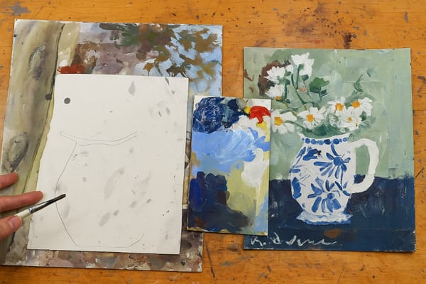 Art table with expressive mixed media flower painting in progress alongside brushes and collage paper